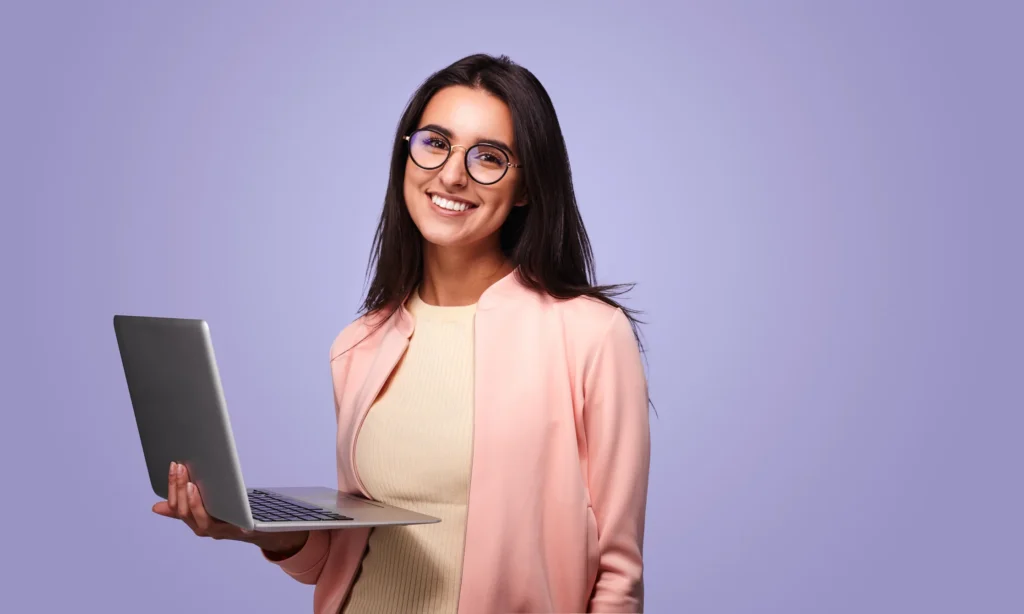 A woman in glasses holding a laptop.